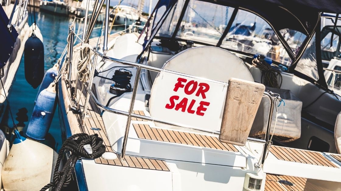 Plachetnica s nápisom For Sale, predaj ojazdenej lode